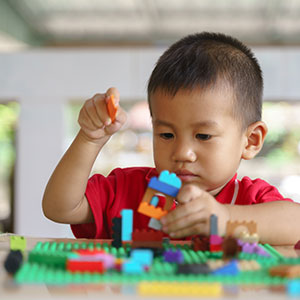 little asian boy playing with lego