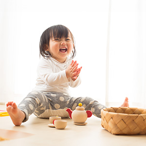 happy smiling chinese toddler playing with toys during a mandarin class