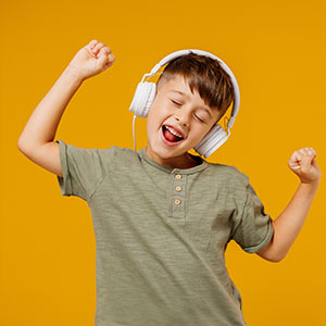 little boy dancing whilst listening to music in a music lesson at